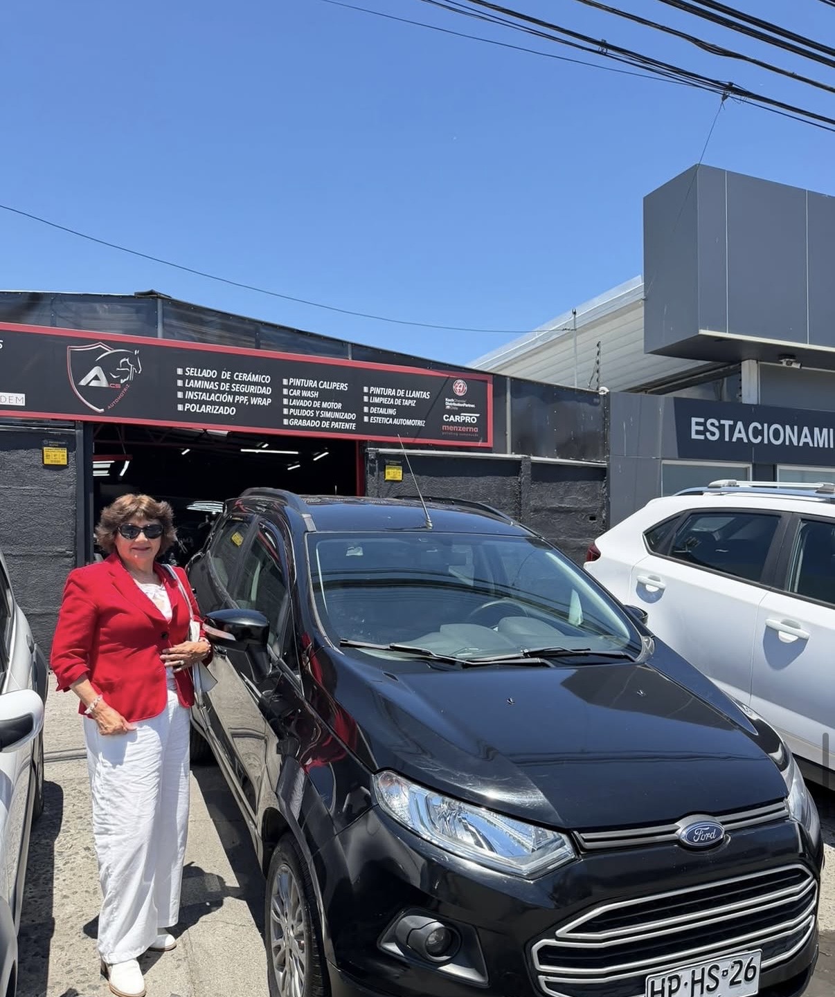 Clienta junto a su Ford Ecosport negro vendido en ACS Automotriz
