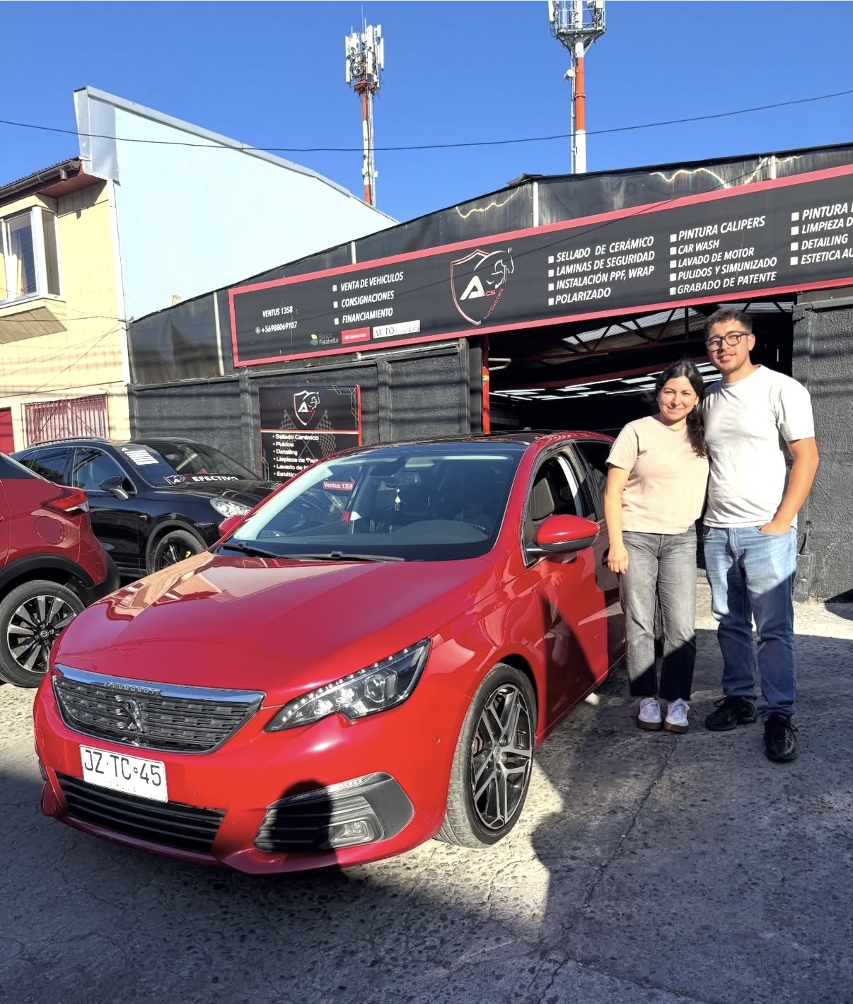 Pareja recibiendo su Peugeot 308 rojo vendido en ACS Automotriz